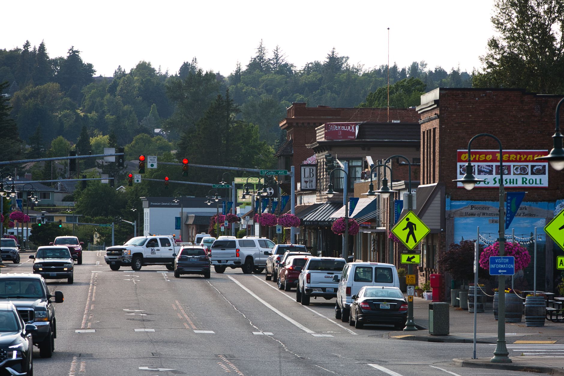 Lively urban street with cars, shops, and pedestrians during daytime. — 5 Ways Marketing Clothing Helps Your Branding