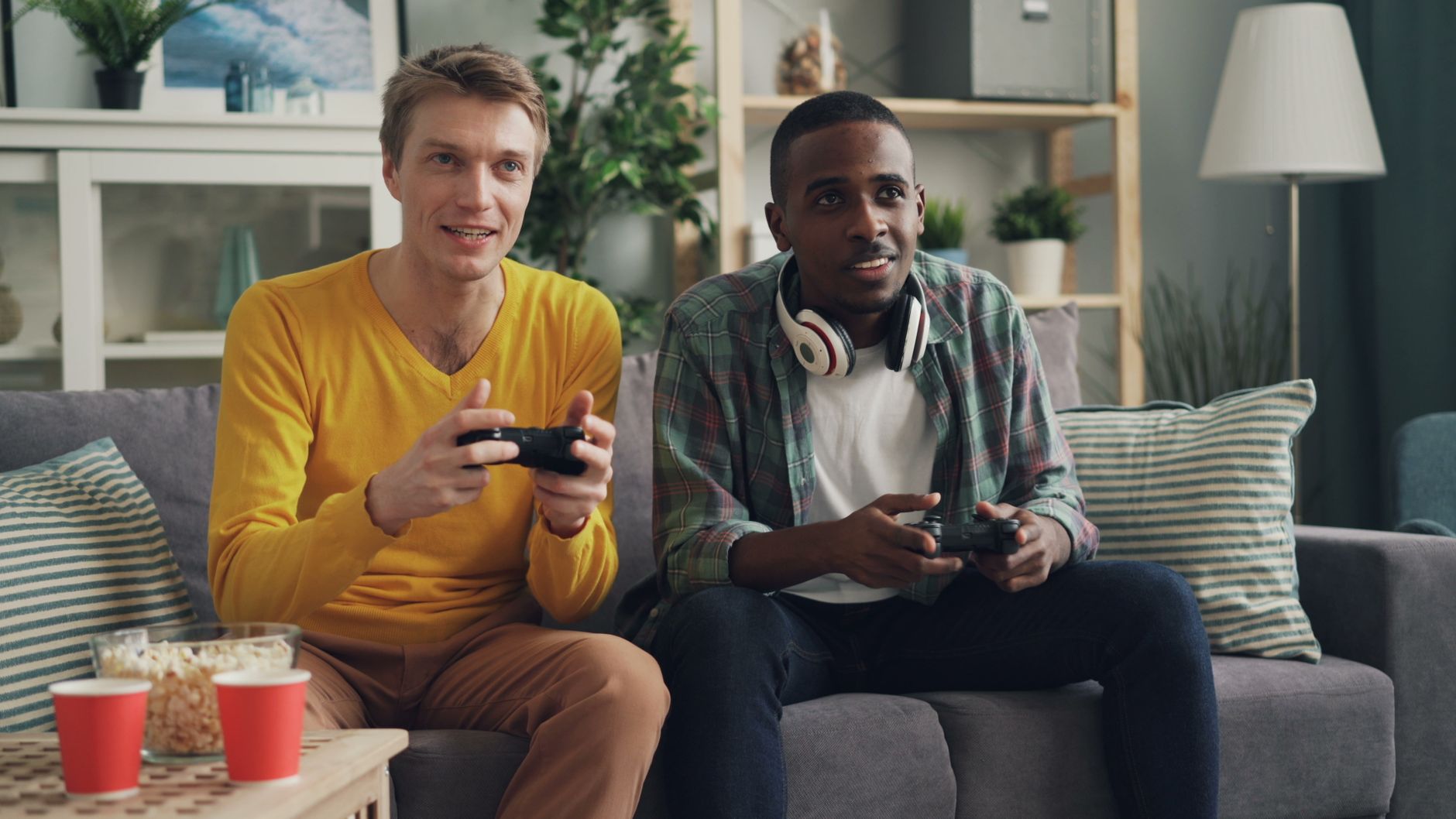 Two men sitting on a couch playing video games, focused and engaged. — A Comparison of the Best Online Casino Loyalty Program