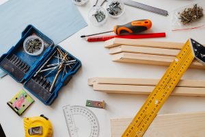 A top view of various woodworking tools and materials on a white table. — Asbestos Survey Best Practices: Ensuring Safety and