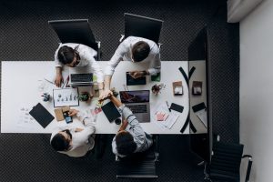 High angle view of colleagues collaborating around a conference table in a modern office setting. — Brand Development Part 1