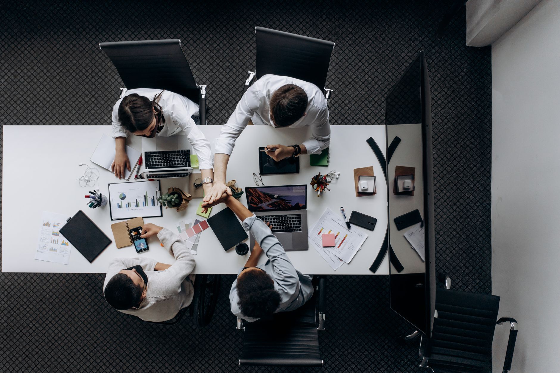 High angle view of colleagues collaborating around a conference table in a modern office setting. — Brand Development Part 1