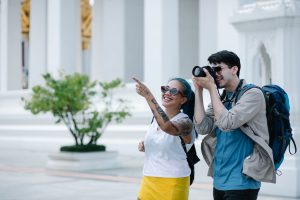 A smiling man and woman explore architectural landmarks with a camera, embracing travel and photography. — Bring Your Job on