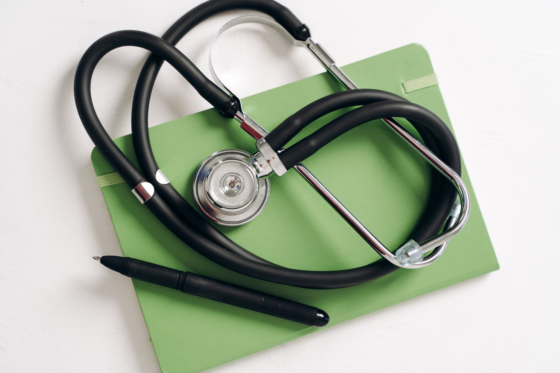 Top view of a stethoscope and pen on a green notepad, ideal for medical and educational themes. — CBD Oil And Diabetes
