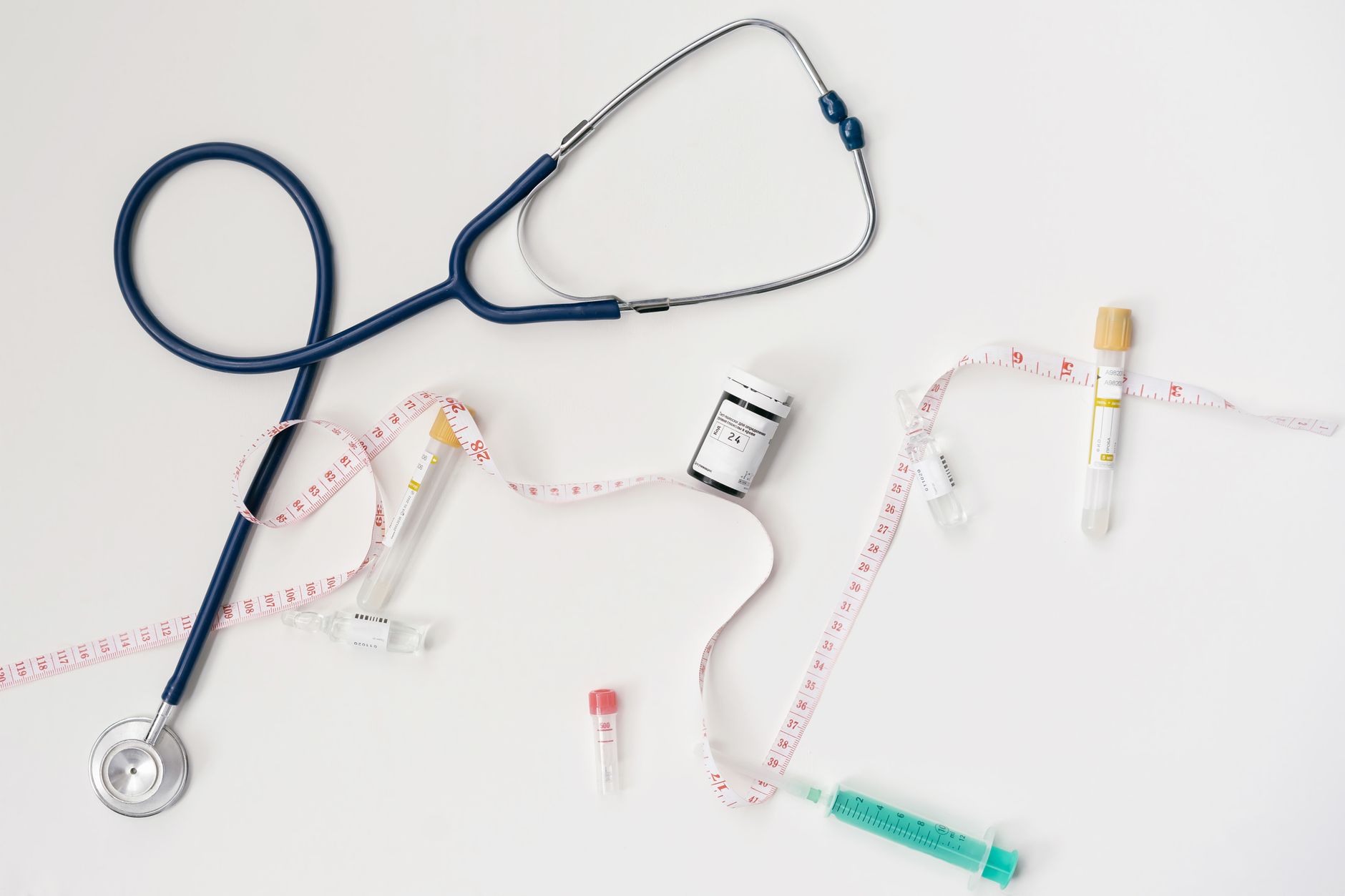 Top view of stethoscope, syringes, and tape measure on white background. — Different Payment Options for Weed Delivery Vancou