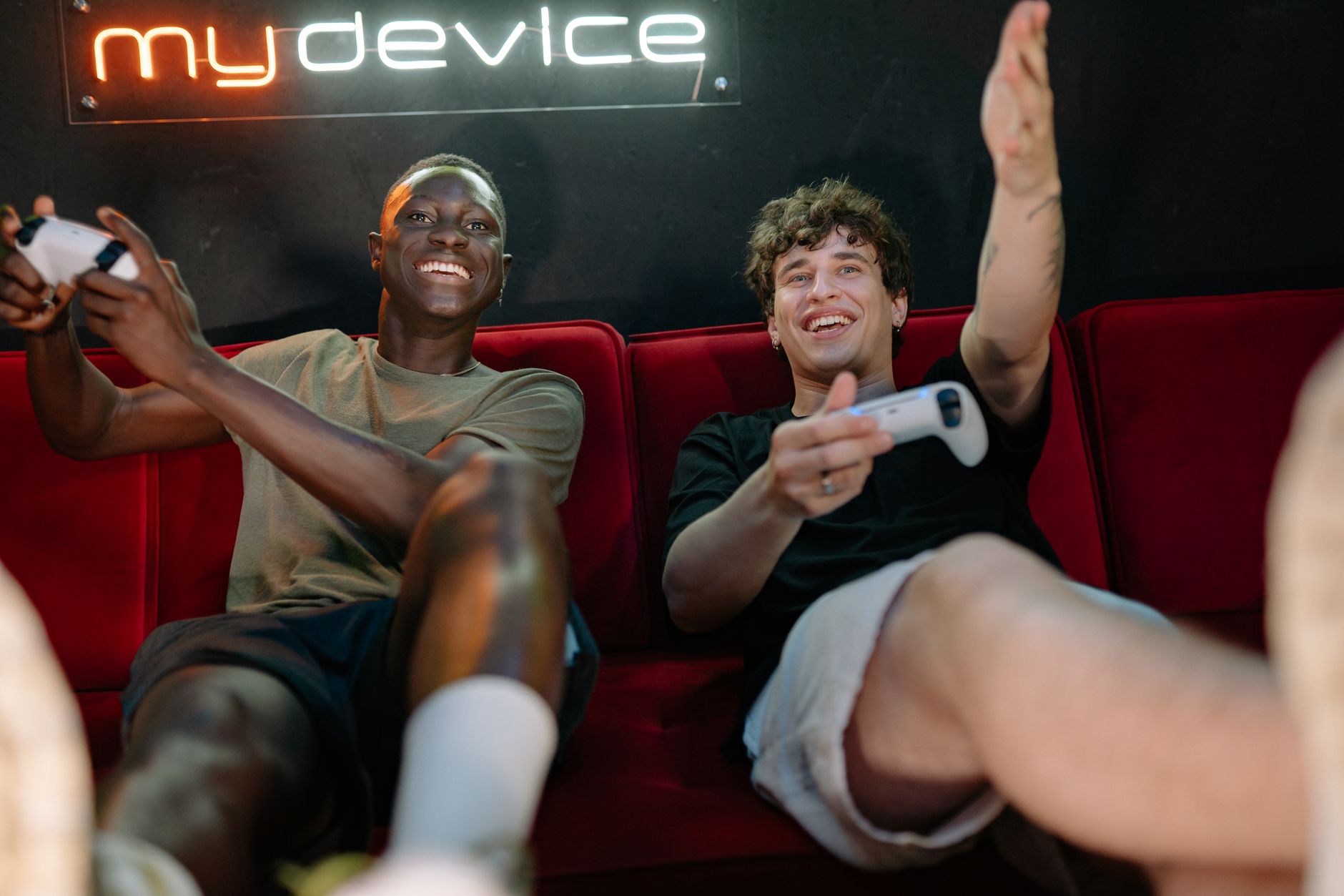Two friends having fun and playing video games on a couch indoors. — Exploring Different Strategies for Winning at Live Deale