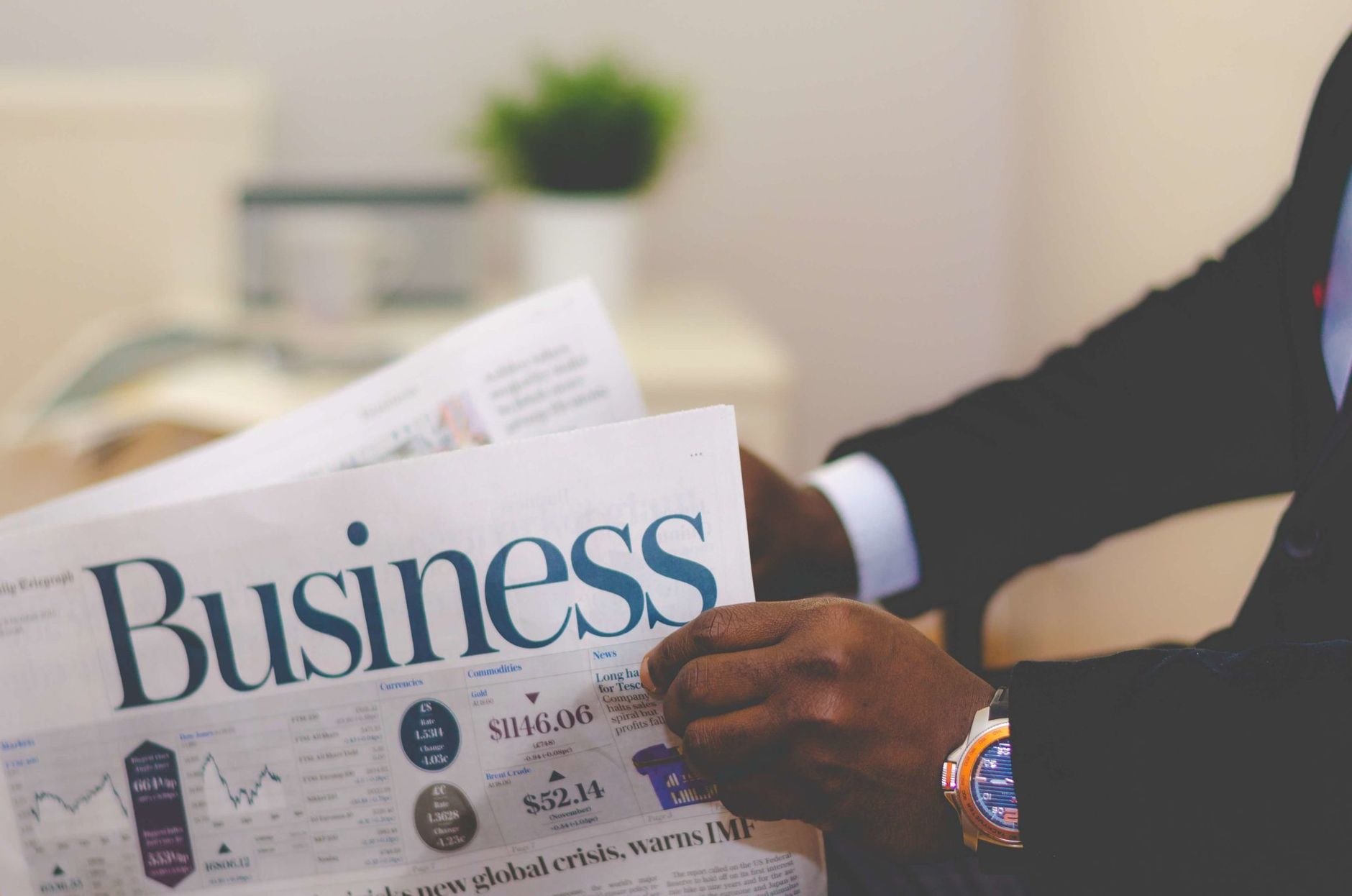 Close-up of a businessman reading a newspaper indoors, focusing on business headlines. — Exploring Medicare Advantage for Vet