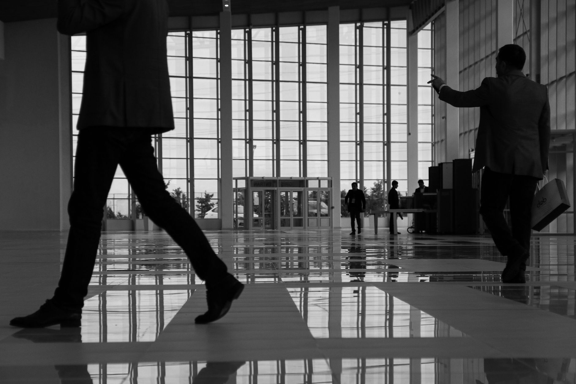 Business professionals walk through a modern, glass-paneled indoor space. — How to Make Your Money Work for You with SIP Inve