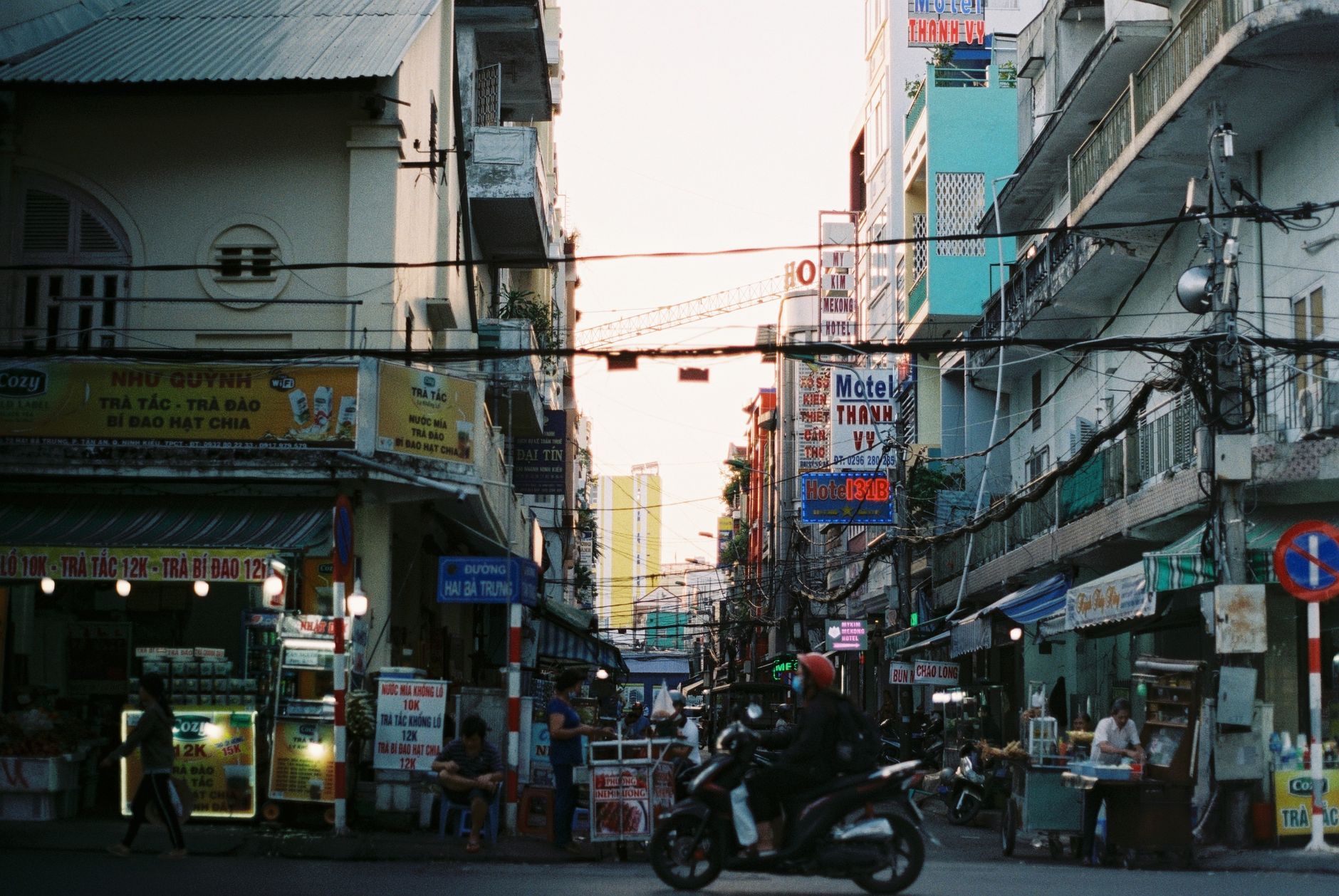 Colorful busy street scene in Cần Thơ, Vietnam with vibrant signs and people. — Introduction to Audio Mastering