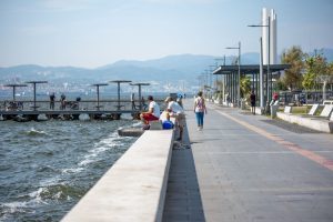 Serene seaside promenade with people fishing and strolling by the pier, set against coastal views. — Jackpots Usually Range I