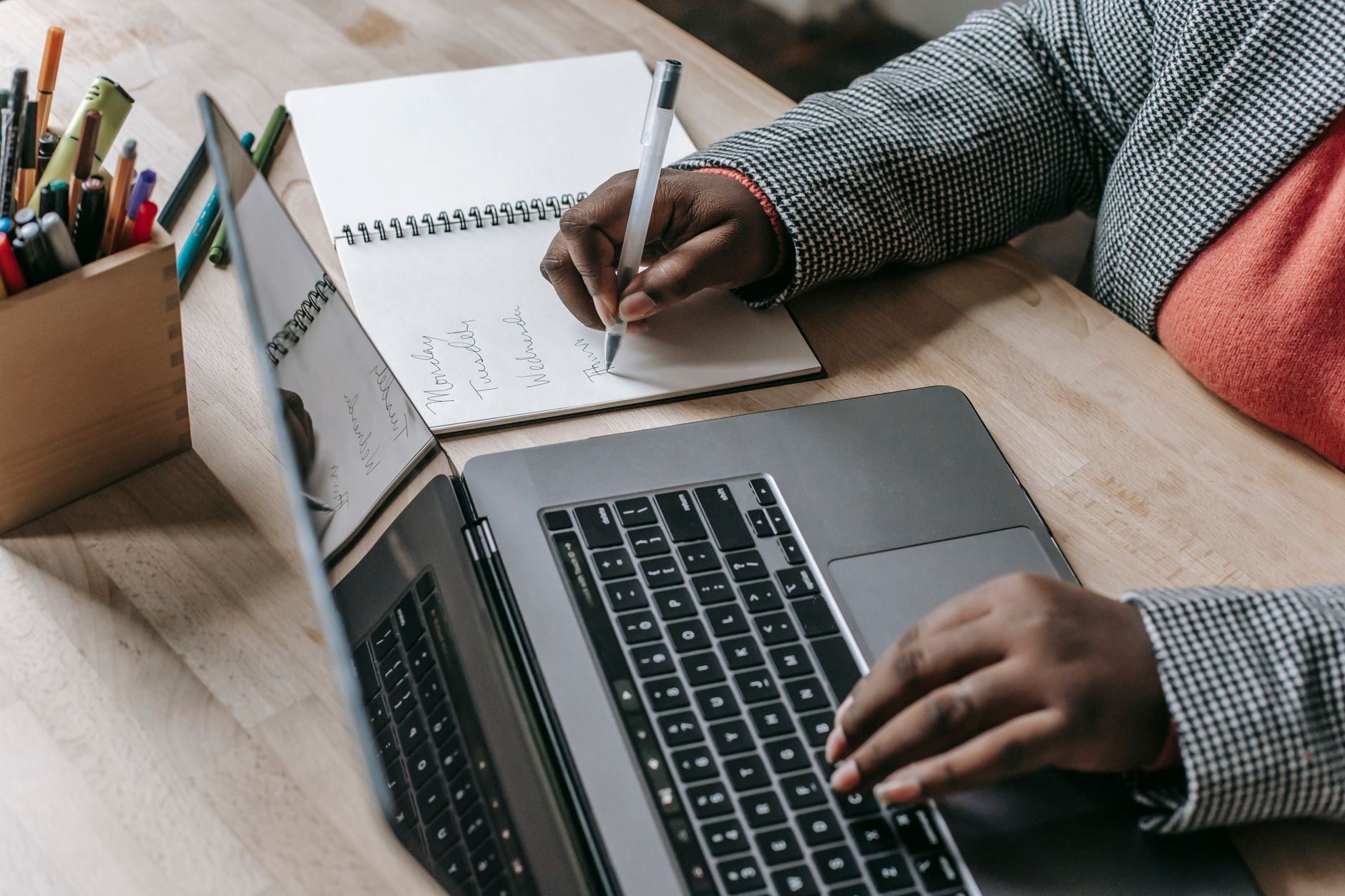 Crop unrecognizable African American female in formal wear writing notes in notepad while working on laptop — Know-How To Cho