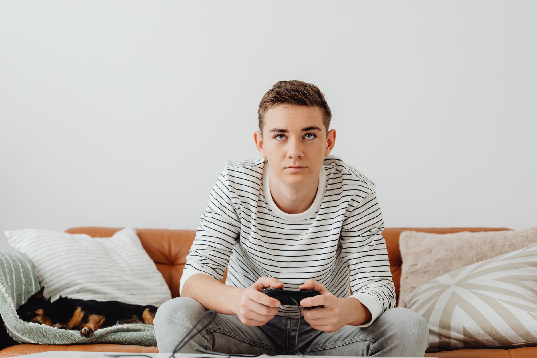 Teen boy intensely focused on video games at home, relaxing on a couch. — Play for Hours and Win Big with Canadian Online Slo