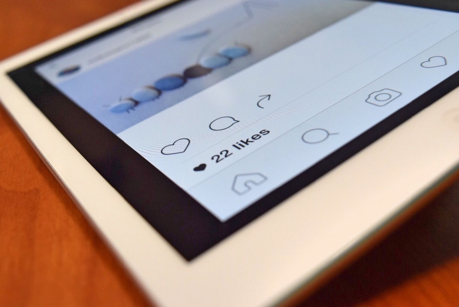 Photo of a tablet displaying a social media app interface with 22 likes, highlighting digital interaction. — Put Yourself in