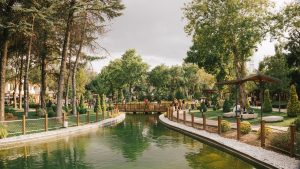 Peaceful park scene featuring a serene pond, a wooden bridge, and lush greenery. — Registracija bez depozita za brzu igru odm