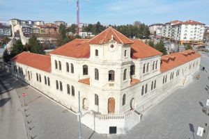 Aerial view of a historic stone building with red tile roofs in Sivas, Turkey, on a sunny day. — Steps to Add Image to PDF