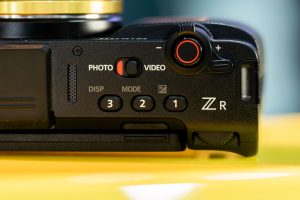 Detailed close-up of a camera's control interface featuring buttons and dials, emphasizing its design and functionality. —