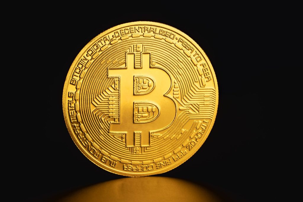 Close-up of a golden Bitcoin coin on a dark background symbolizing cryptocurrency and digital finance. — Technology - By Help