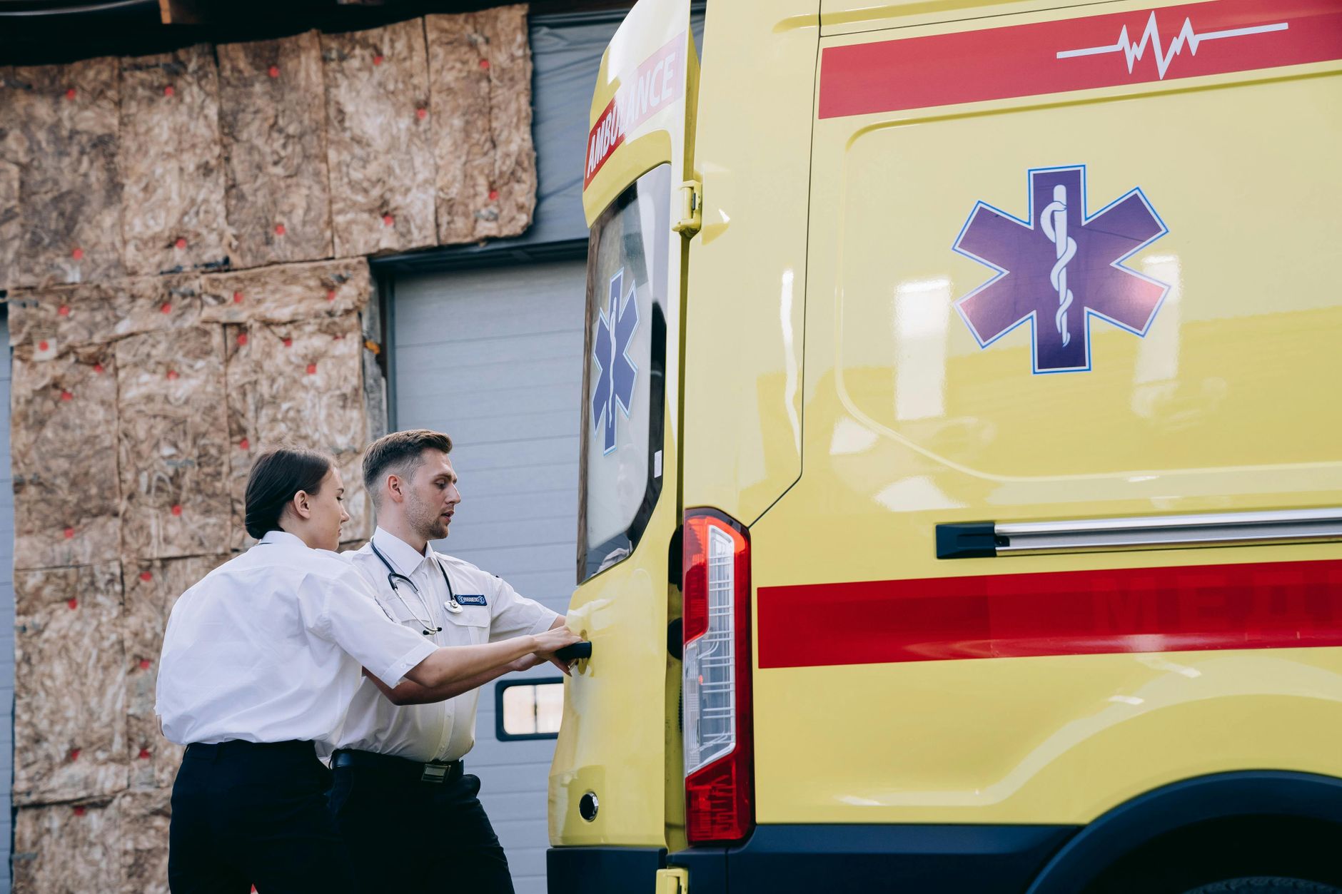 Two paramedics close the rear doors of an ambulance, preparing for emergency response. — Tend To Be More Seniors Individuals