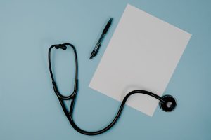 Flat lay of stethoscope, blank paper, and pen on blue surface — The Benefits of Medicare Supplement Plans in 2025: What You S