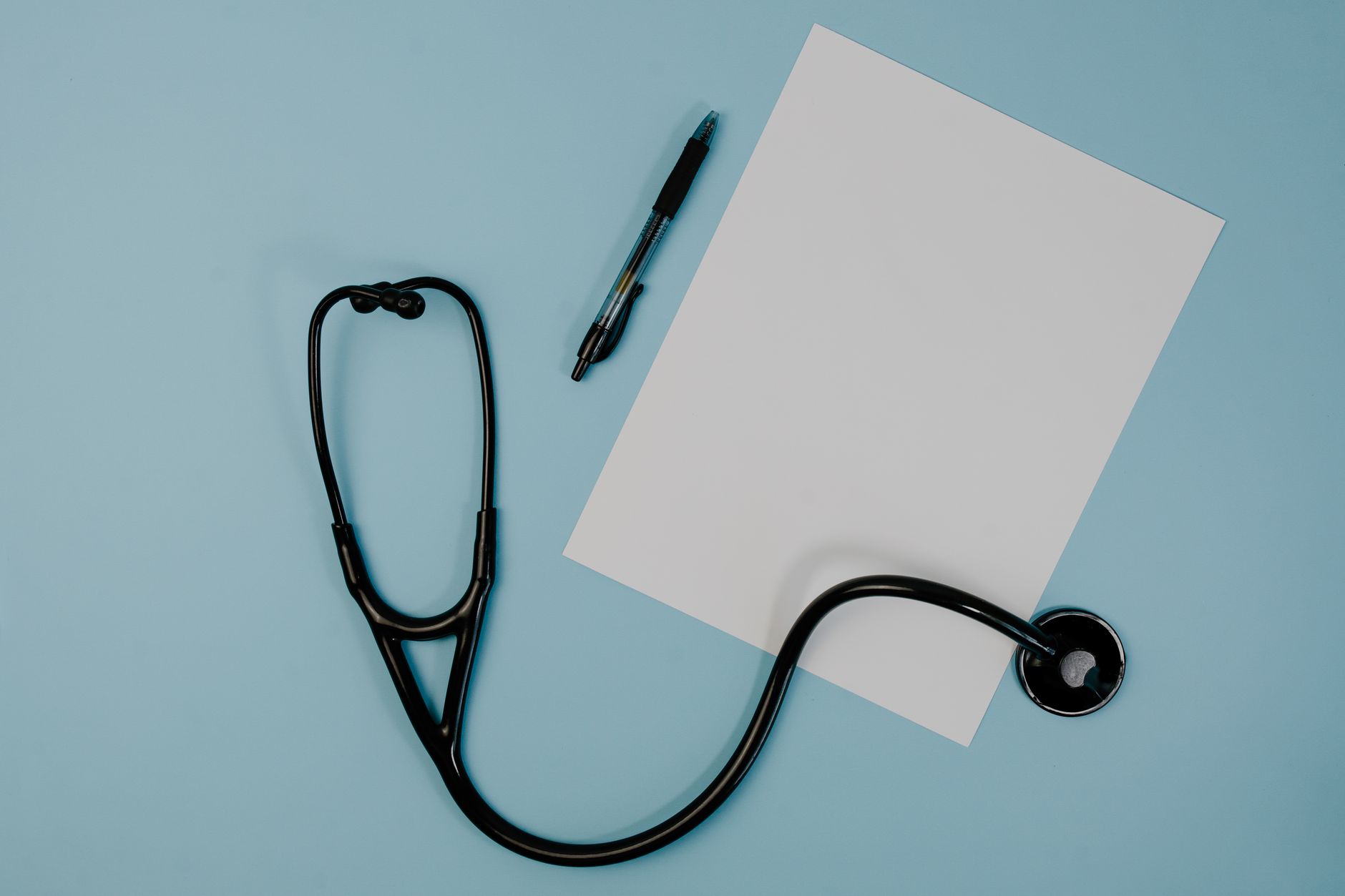 Flat lay of stethoscope, blank paper, and pen on blue surface — The Benefits of Medicare Supplement Plans in 2025: What You S