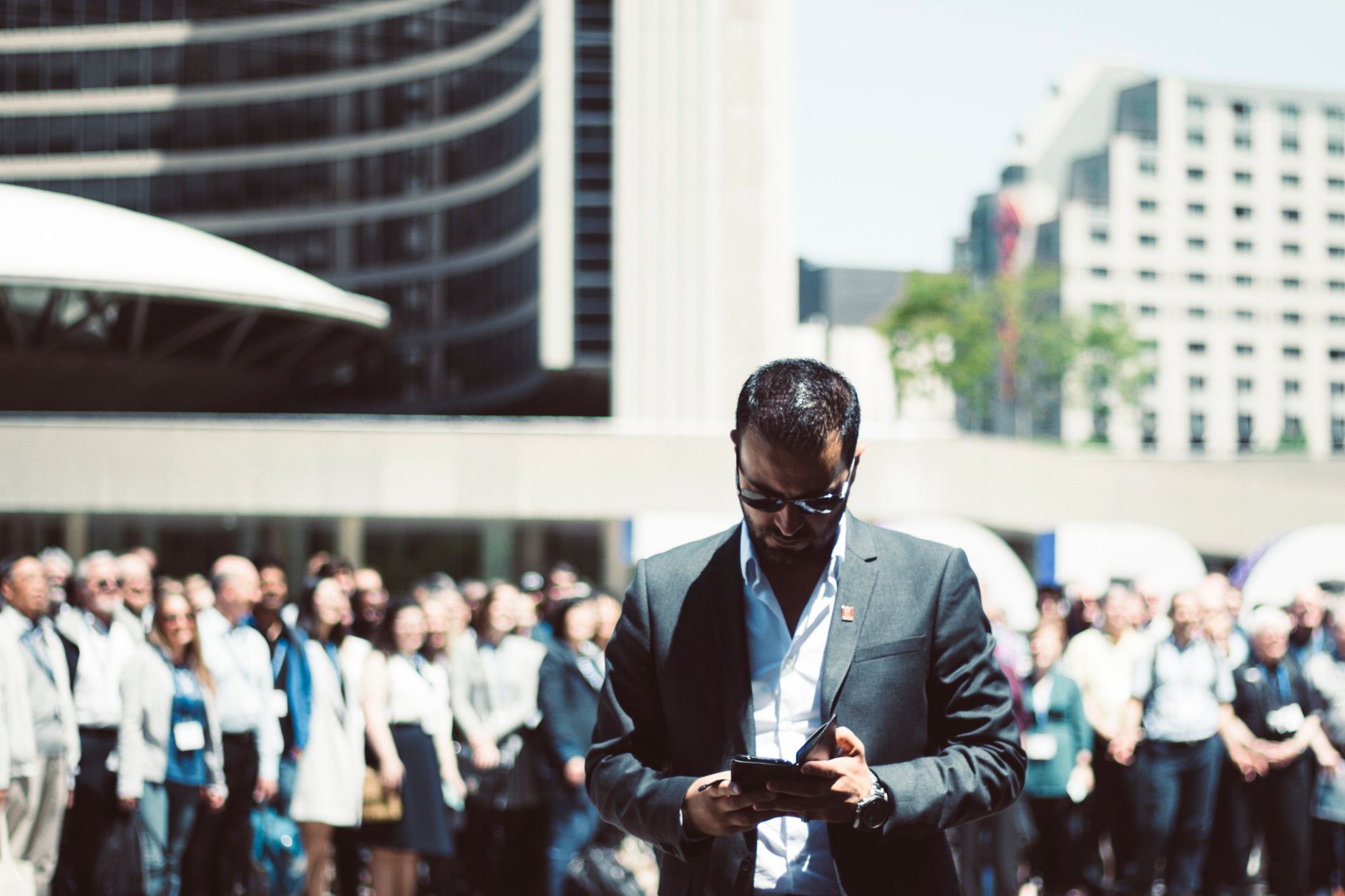 Focused businessman using tablet in a bustling crowd in Toronto's busy urban setting. — The Evolution of Hormonal Health: The