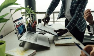 Colleagues collaborating on financial data analysis with a laptop in the office. — Tips to Find the Best Part-Time Jobs For W