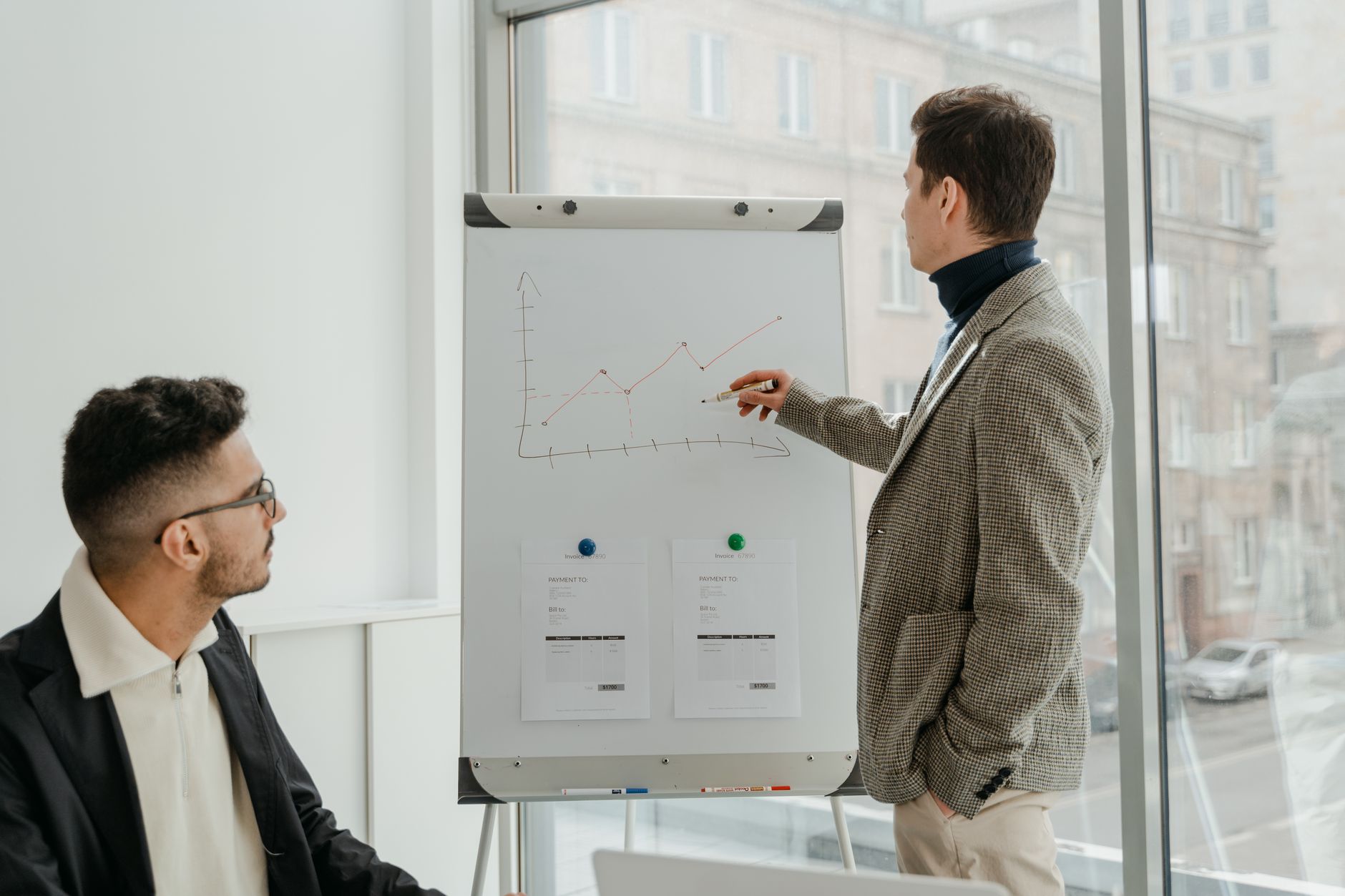 Two professionals examining graphs during an office presentation. — Understanding the Technology Behind IPTV Smarters Pro