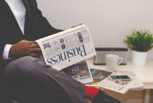 Businessman reading a financial newspaper at a desk, highlighting finance and commerce theme. — Unveiling the 2024 Aetna Medi