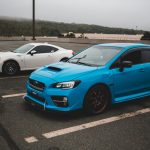 Modern fast clean automobiles parked on concrete surface with stripes on gloomy cloudy day — What Let's Focus On Automotive S