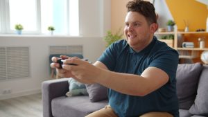 Man intensely focused on playing video games in a comfortable living room setting. — Why an Eat and Run Verification Site Hel